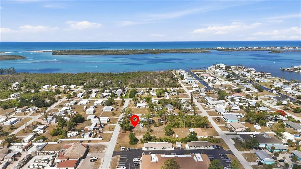 An aerial view shows a vacant lot marked with a red pin in a coastal neighborhood — 1970 KENTUCKY AVENUE, ENGLEWOOD, FL
