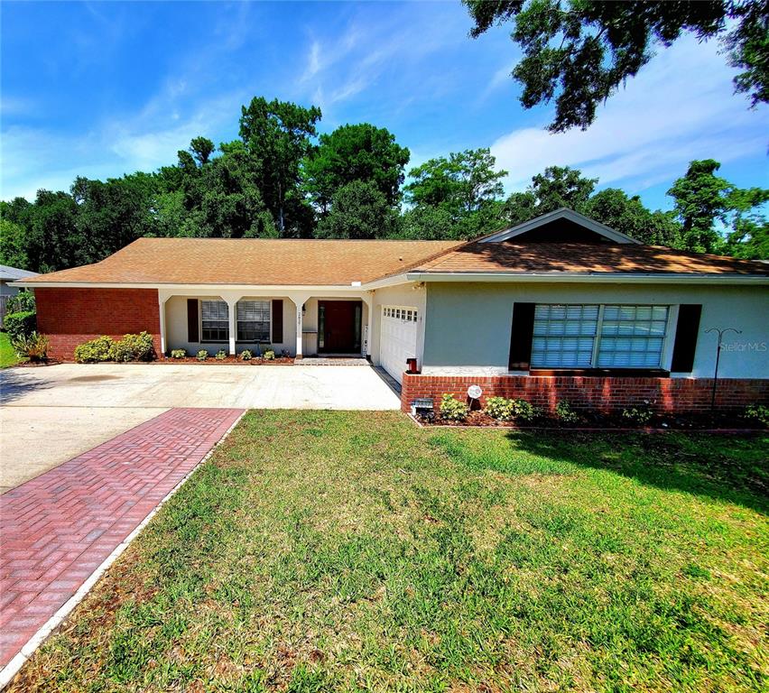 A single-story house with a brick and stucco exterior, a brown roof, and a driveway — 2837 LONGLEAF LANE, PALM HARBOR, FL