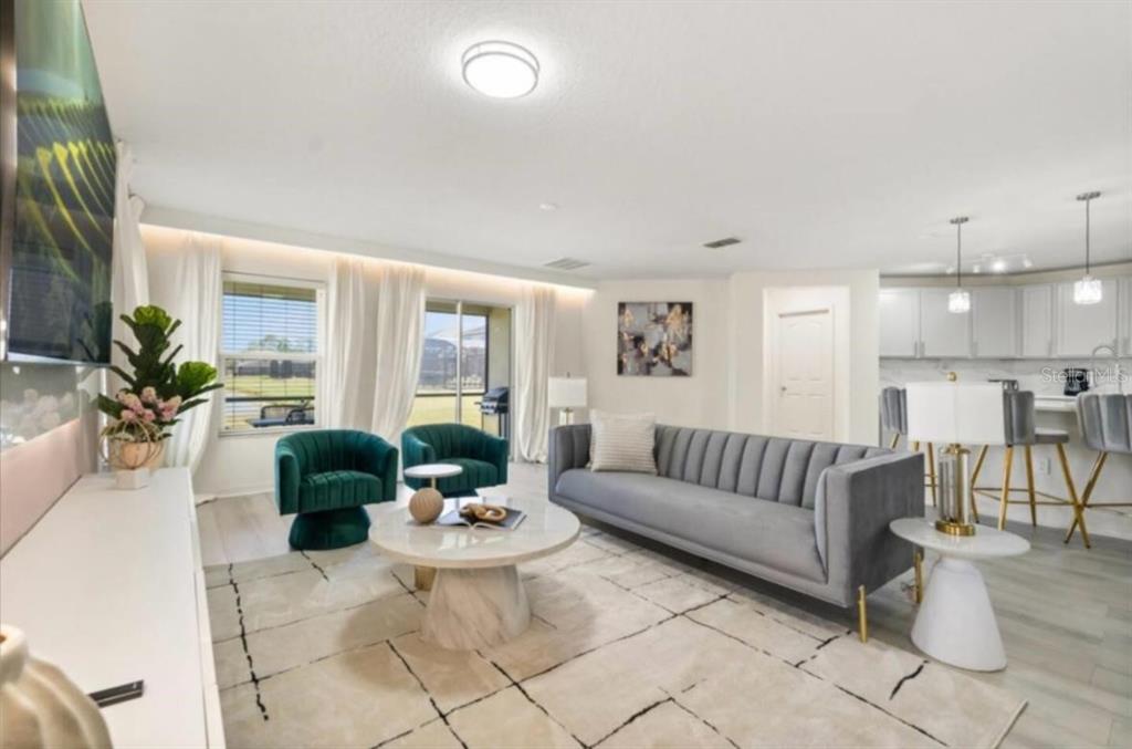 A living room features a grey sofa, two green velvet chairs, and a marble coffee table — 4717 BLUE DIAMOND STREET, KISSIMMEE, FL