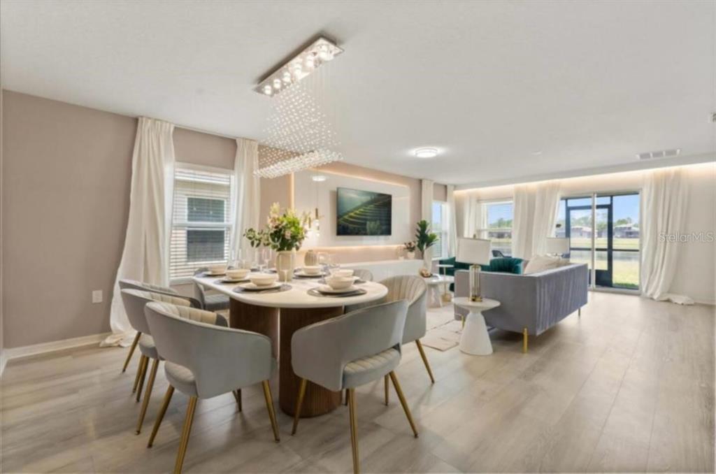 A dining area and living room with light wood floors, modern furniture, and a chandelier — 4717 BLUE DIAMOND STREET, KISSIMMEE, FL