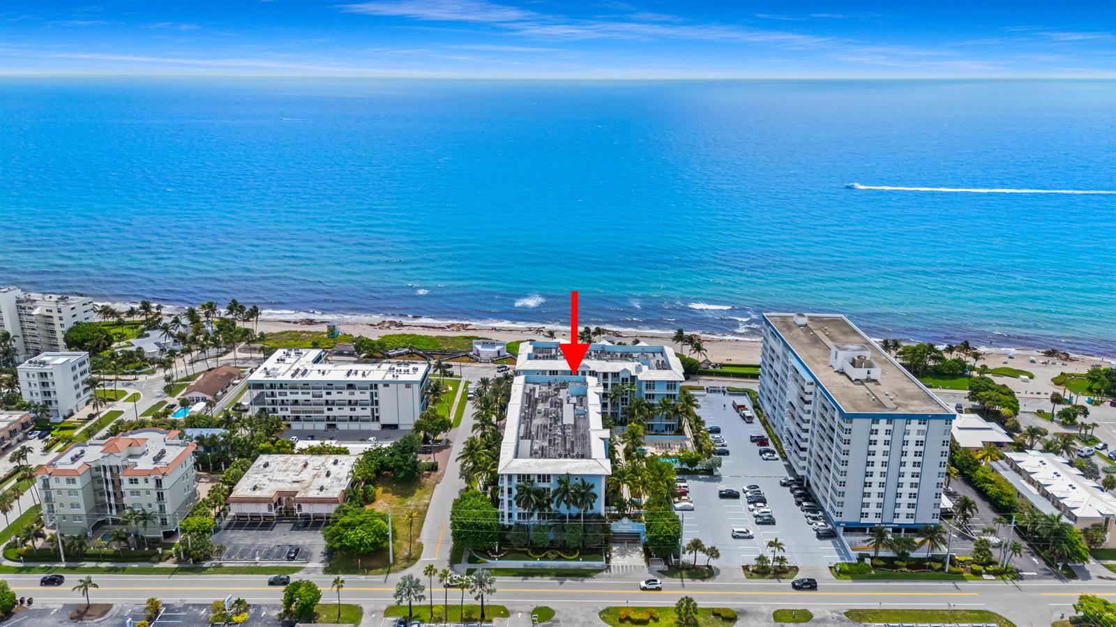 An aerial view shows a multi-story apartment building near the ocean with a red arrow — 701 SE 21st Avenue # 501, Deerfield Beach FL 33441, DEERFIELD BEACH, FL
