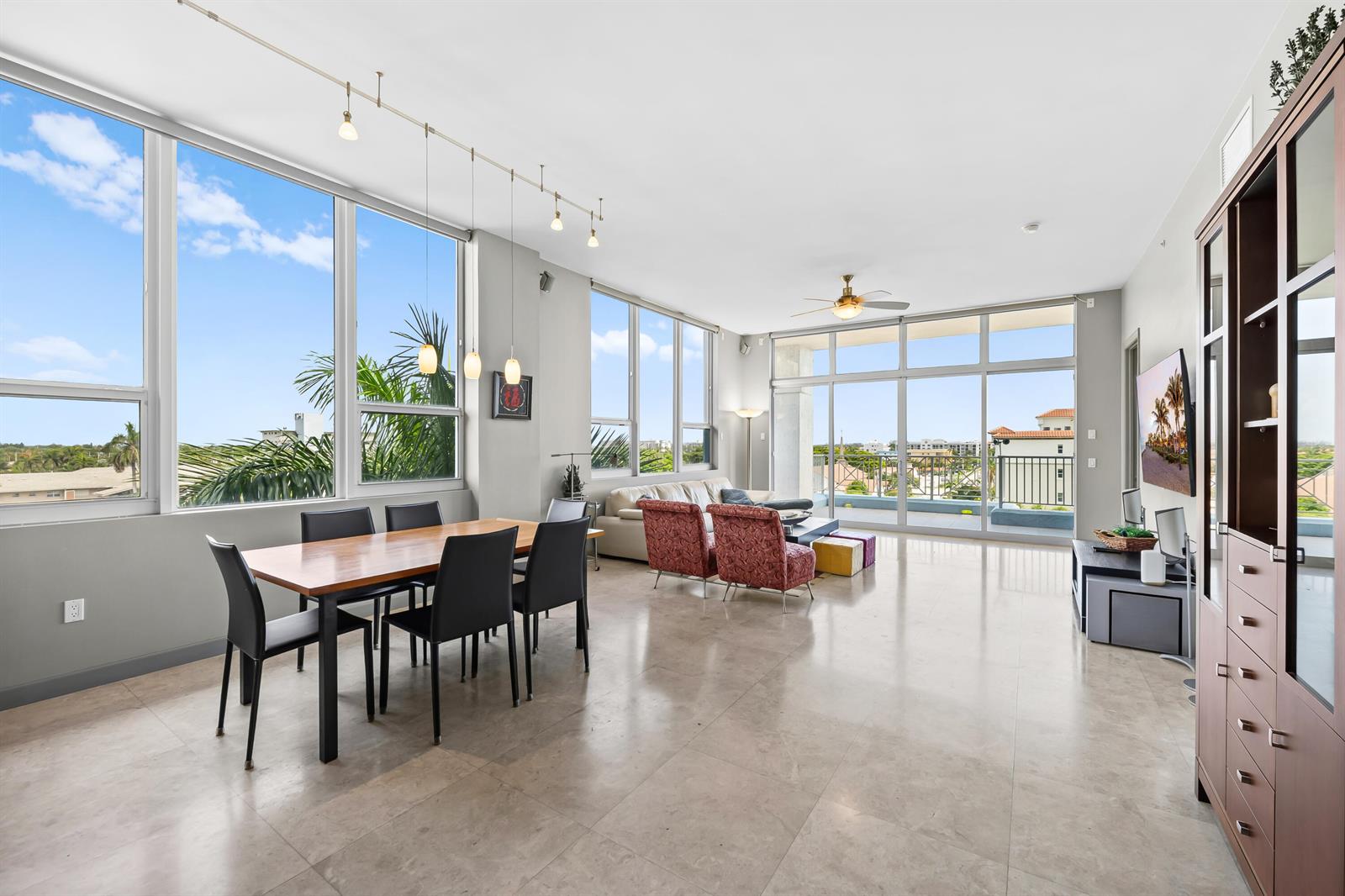 A spacious open-concept living and dining area with floor-to-ceiling windows and light tile flooring — 701 SE 21st Avenue # 501, Deerfield Beach FL 33441, DEERFIELD BEACH, FL