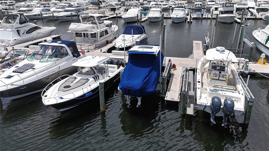 An aerial view shows several boats docked at a marina with calm water — 102 RIVIERA DUNES WAY UNIT N-21, PALMETTO, FL