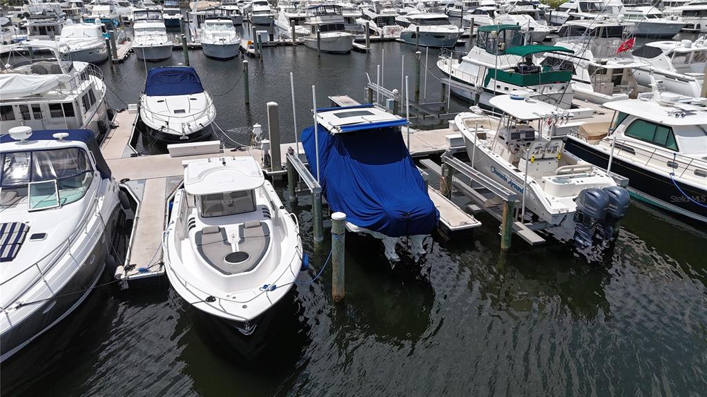 An aerial view shows several boats docked in a marina with calm water — 102 RIVIERA DUNES WAY UNIT N-21, PALMETTO, FL