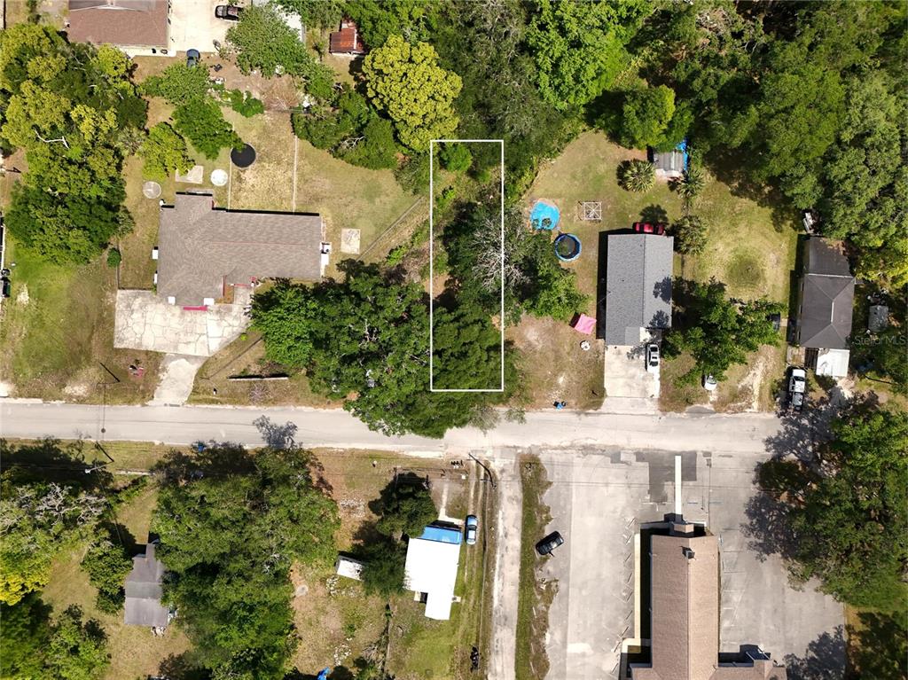 An aerial view shows a vacant, rectangular lot outlined in white between two residential properties — JOSEPHINE STREET, BROOKSVILLE, FL