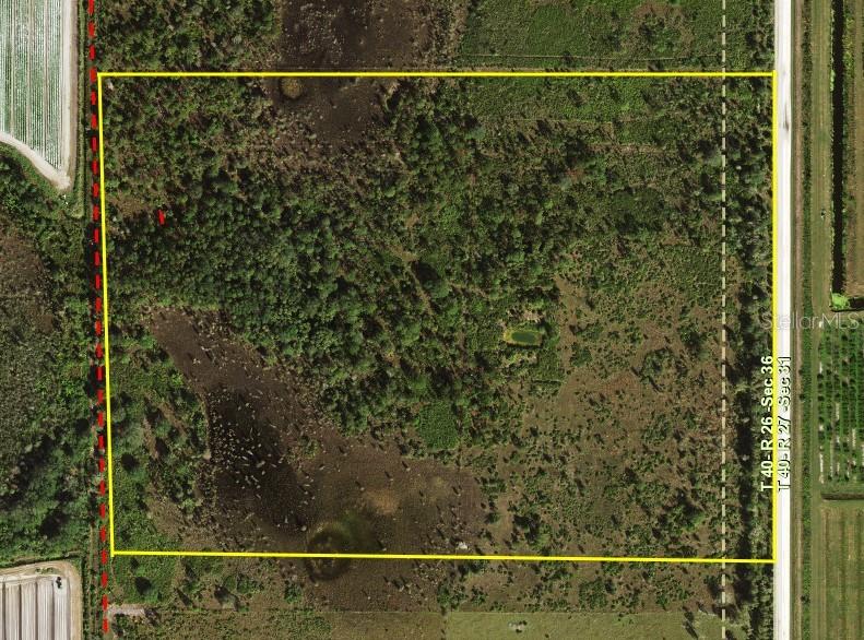 An aerial view shows a rectangular plot of undeveloped land with trees and vegetation — 5151 CHIQUITA DRIVE, PUNTA GORDA, FL