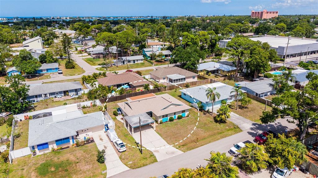 An aerial view shows a residential neighborhood with houses, driveways, and surrounding trees — 8824 PHYLISS AVENUE, SARASOTA, FL