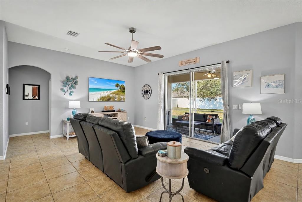 An entryway features tile flooring, a gray bench, wall decor, and a white front door — 222 BIRD OF PARADISE DRIVE, PALM COAST, FL
