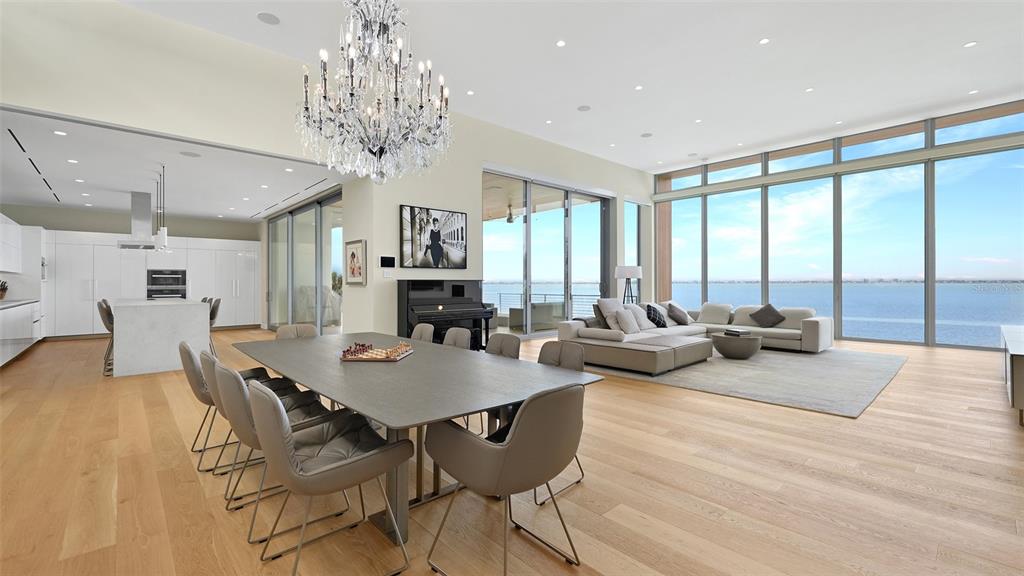 A modern two-story waterfront home features a large infinity pool, glass walls, and a lawn — 4123 BAY SHORE ROAD, SARASOTA, FL