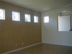 An interior room features a textured tan wall with four small windows and arched opening — 434 N Tangerine Square SW, Vero Beach FL 32968, VERO BEACH, FL