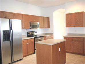 A kitchen with wood cabinets, stainless steel appliances, and a central island — 434 N Tangerine Square SW, Vero Beach FL 32968, VERO BEACH, FL