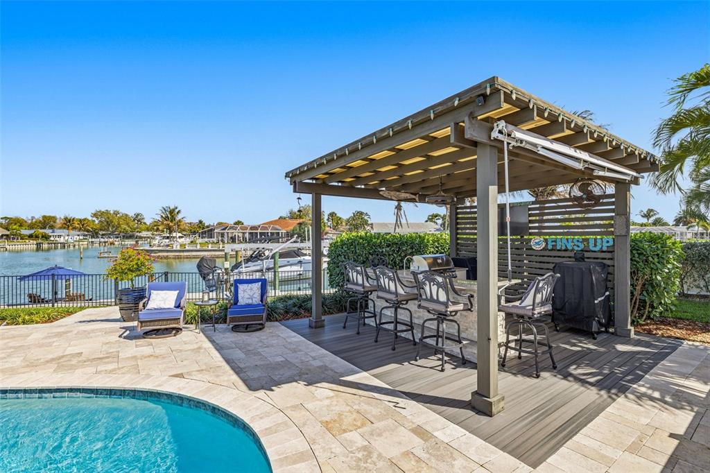 A poolside patio features a wooden pergola covering an outdoor kitchen and bar area — 4310 40TH STREET S, ST PETERSBURG, FL