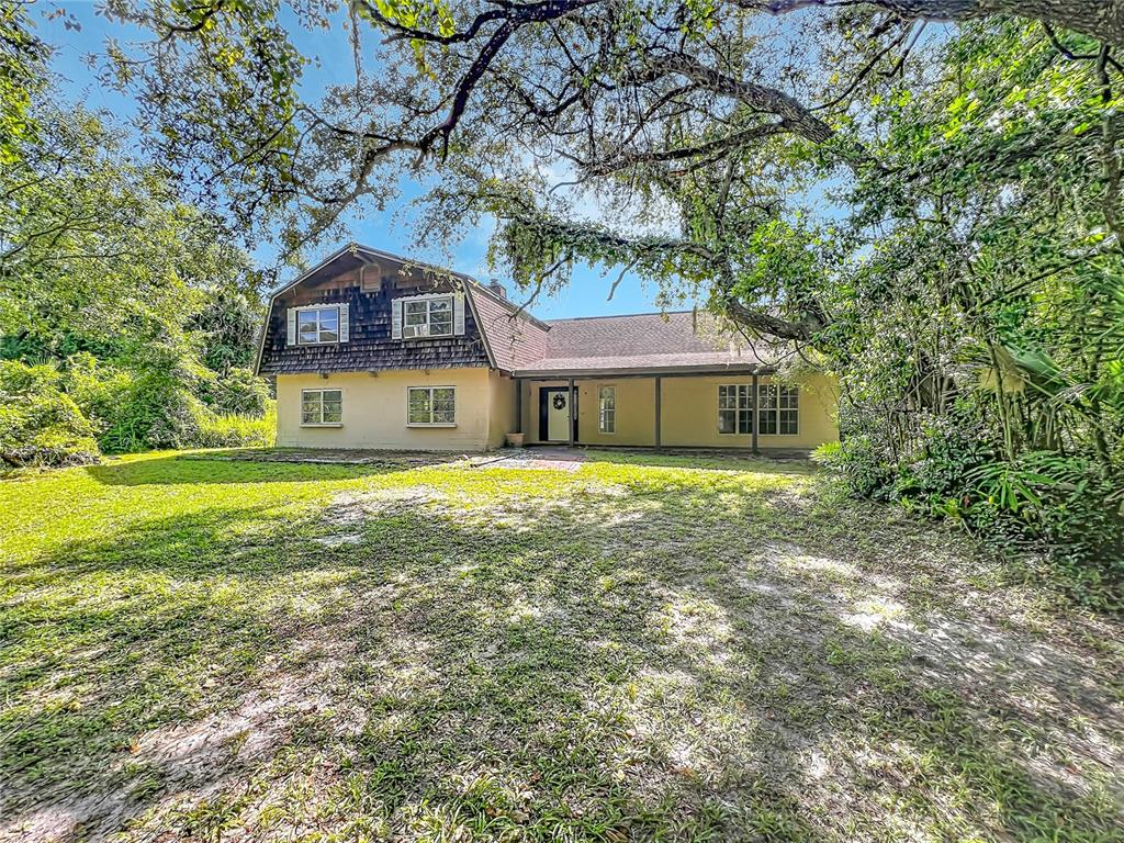 A two-story house with a gambrel roof and a covered porch sits on a lawn — 125 SNOW HILL ROAD, GENEVA, FL