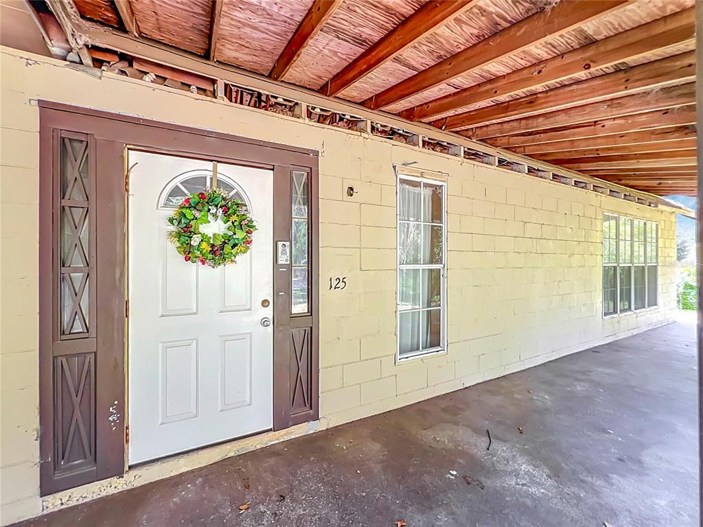 A covered porch leads to a front door with a wreath and sidelights — 125 SNOW HILL ROAD, GENEVA, FL