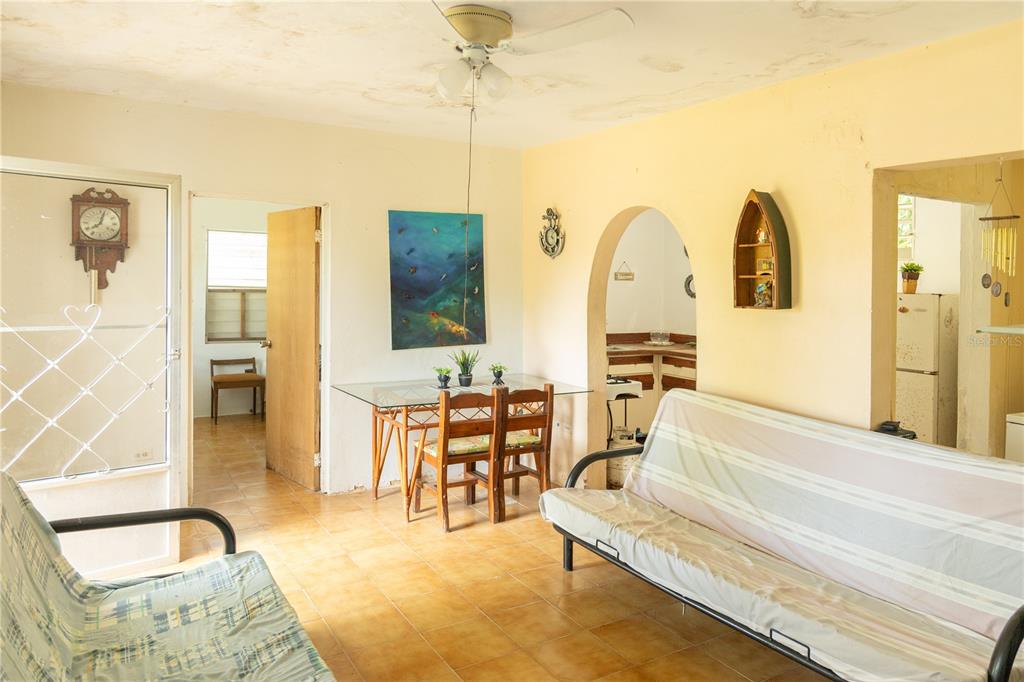 A living and dining area with tile floors, a ceiling fan, and two futons — 16 CALLE SCORPIO, VIEQUES, PR