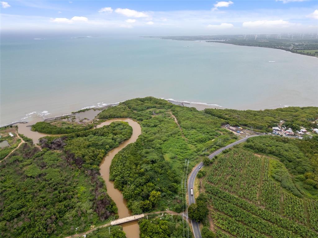 An aerial view shows a winding river meeting the ocean near a road and farmland — PR-1 PUEBLO WARD, SALINAS, PR