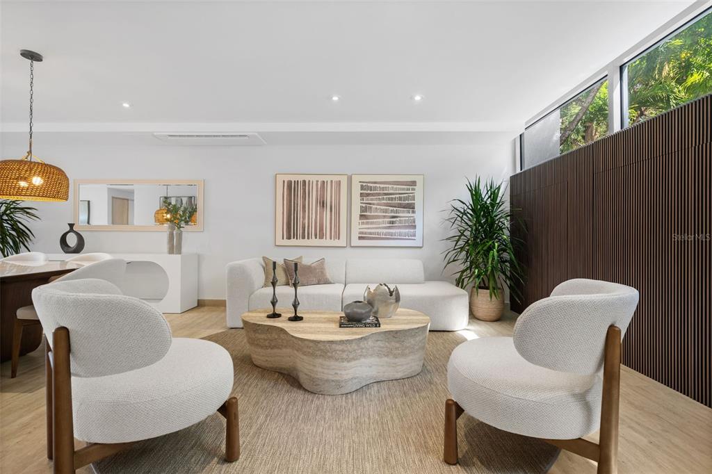 A modern living room features a white sofa, two rounded armchairs, and a stone coffee table — 2613 VILLAS DORADO ESTATES, DORADO, PR
