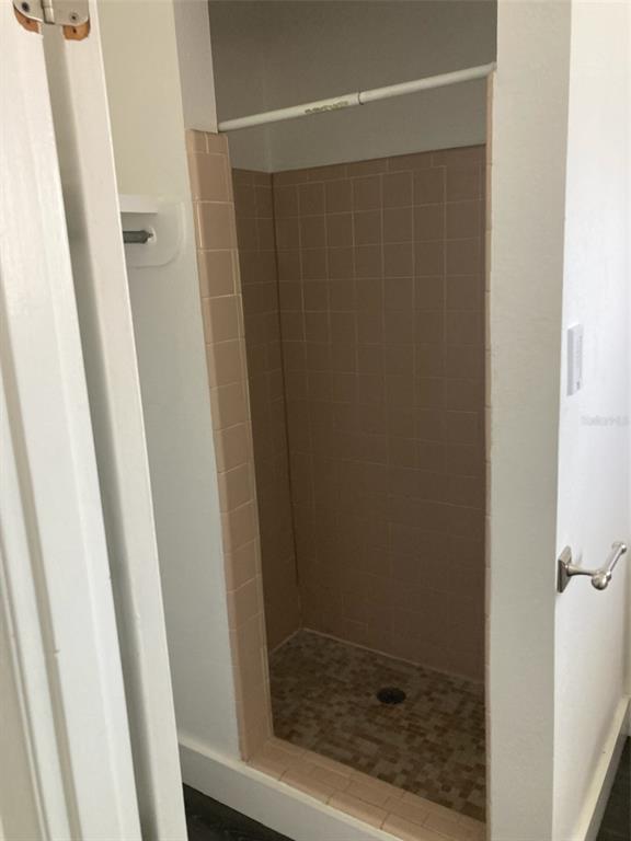 A small shower stall features beige wall tiles and a mosaic-tiled floor — 1401 E ALFRED STREET UNIT 11, TAVARES, FL