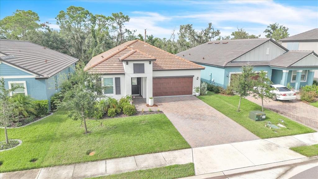 A single-story house with a tiled roof, a brick driveway, and a two-car garage — 14314 17TH COURT E, PARRISH, FL