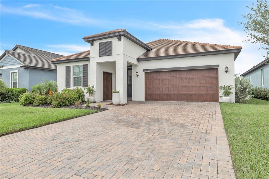 A single-story house with a paved driveway, a two-car garage, and a tiled roof — 14314 17TH COURT E, PARRISH, FL