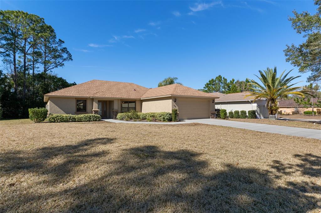 A single-story tan house with a two-car garage and a large front lawn — 2388 N BRENTWOOD CIRCLE, LECANTO, FL