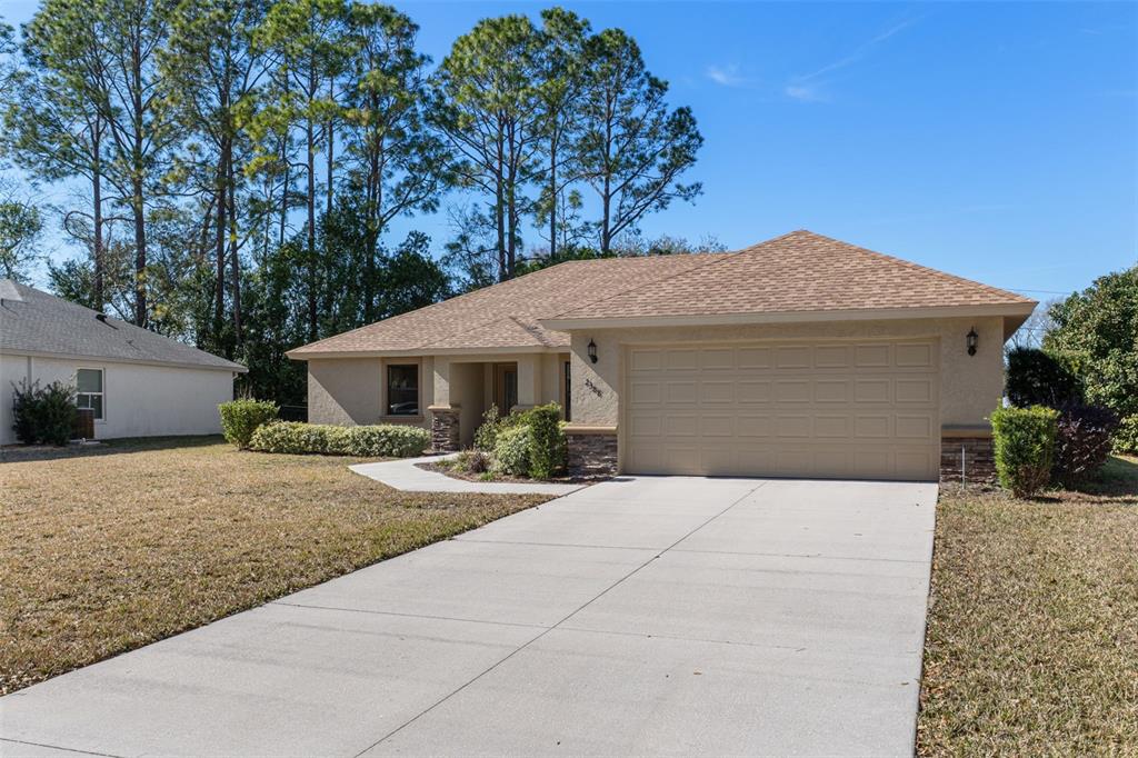 A single-story tan house with a two-car garage and a concrete driveway — 2388 N BRENTWOOD CIRCLE, LECANTO, FL