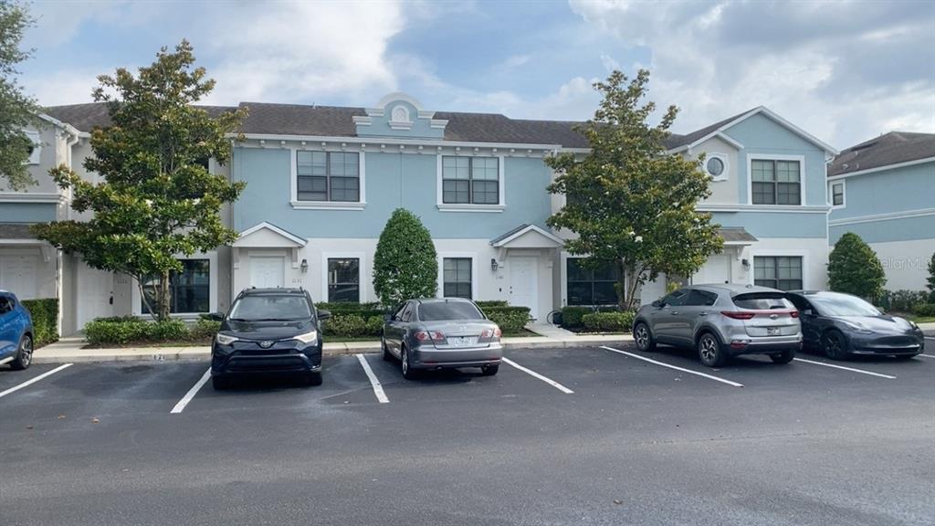 A row of two-story townhomes with light blue siding and a paved parking lot — 1131 TRILLIUM PARK LANE, SANFORD, FL