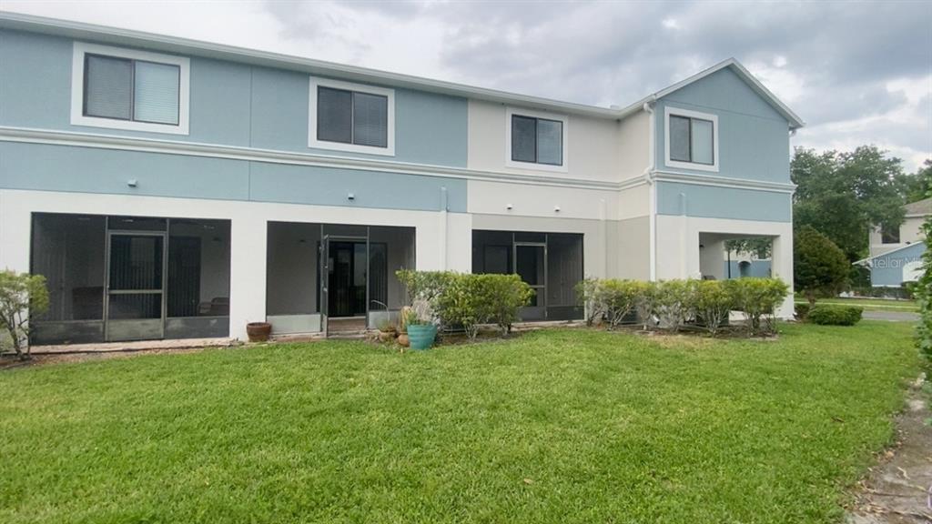 The exterior of a two-story townhouse features blue and white siding with screened-in patios — 1131 TRILLIUM PARK LANE, SANFORD, FL