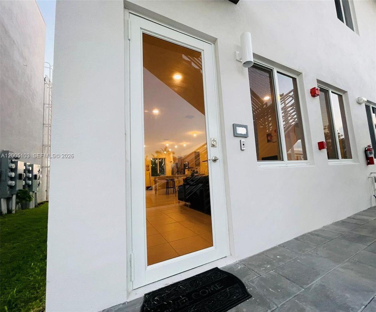 A white exterior door with a glass panel leads into a tiled living space — 10300 NW 66TH AV # 101, Doral FL 33178, DORAL, FL