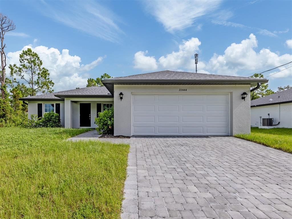 A single-story house with a white stucco exterior, a two-car garage, and a paved driveway — 22444 DONALDA AVENUE, PORT CHARLOTTE, FL
