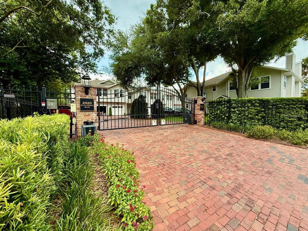 An aerial view shows a residential neighborhood with a pink arrow pointing toward a building — 2920 W EL PRADO BOULEVARD UNIT 12, TAMPA, FL