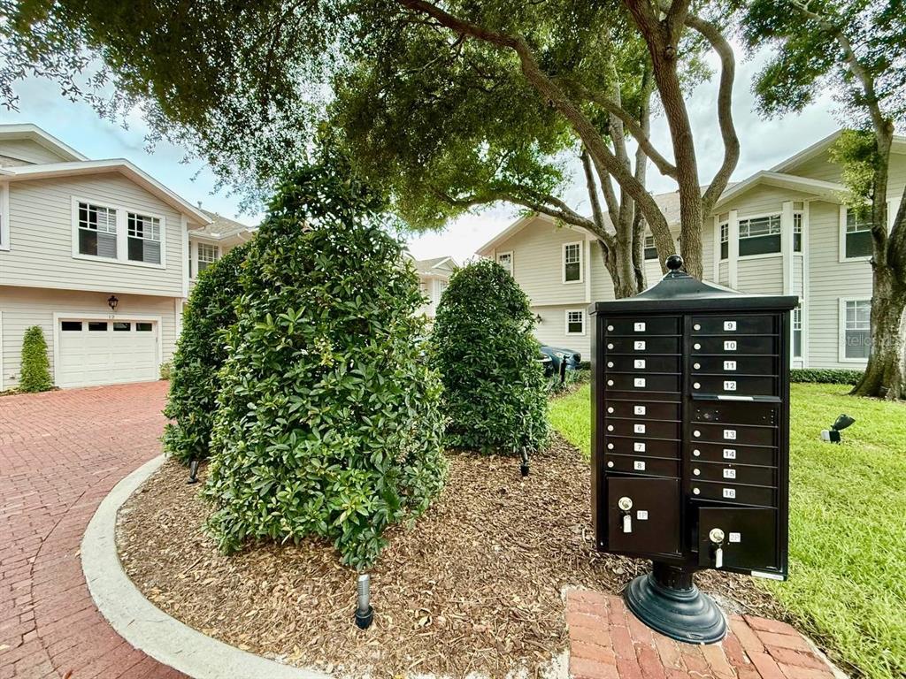 An aerial view shows a row of townhouses with gray roofs near a coastal city — 2920 W EL PRADO BOULEVARD UNIT 12, TAMPA, FL