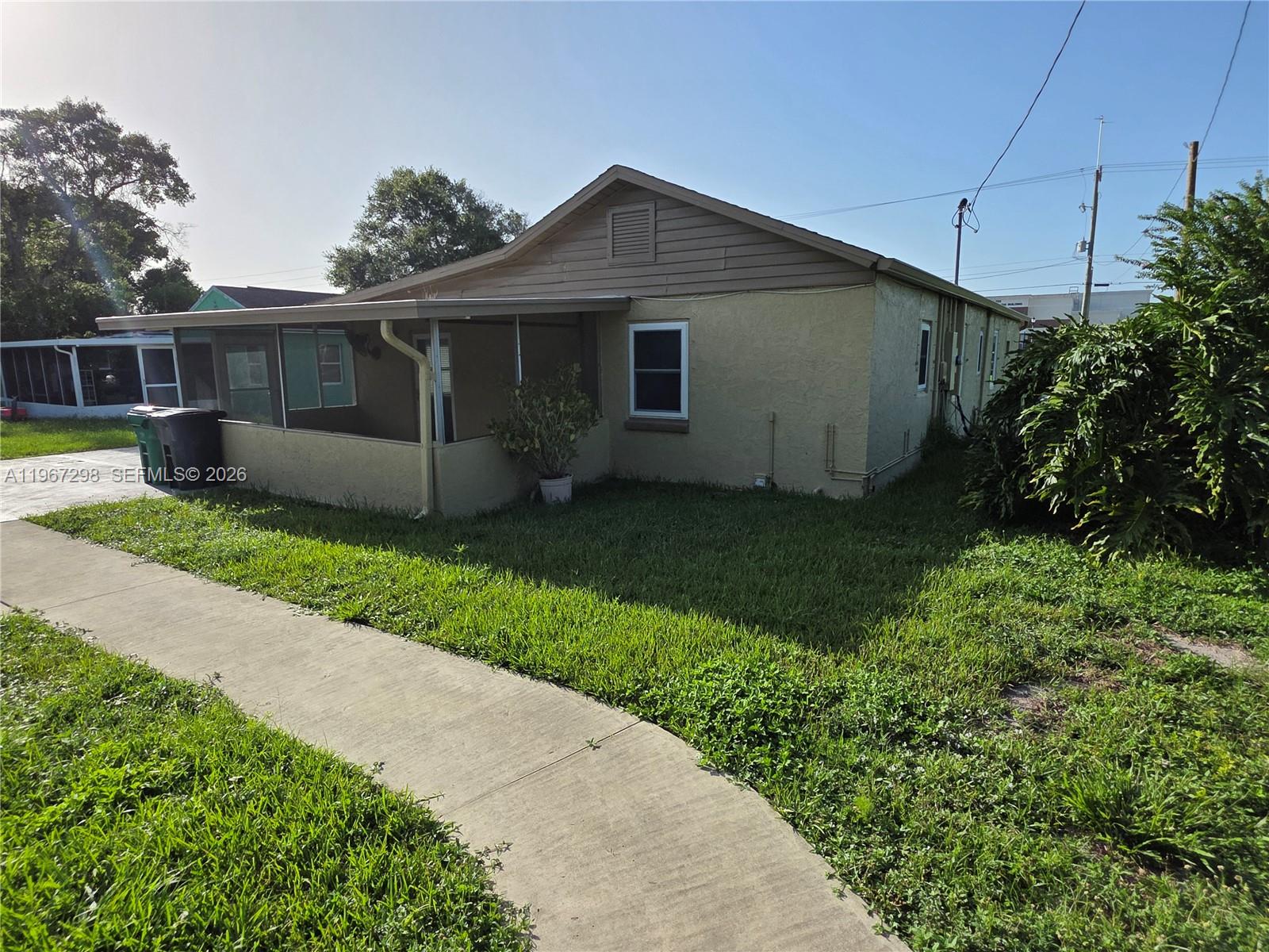 A beige single-story house features a screened-in porch and a concrete walkway — 4321 Kirby Loop Rd # 1, Fort Pierce FL 34981, FORT PIERCE, FL
