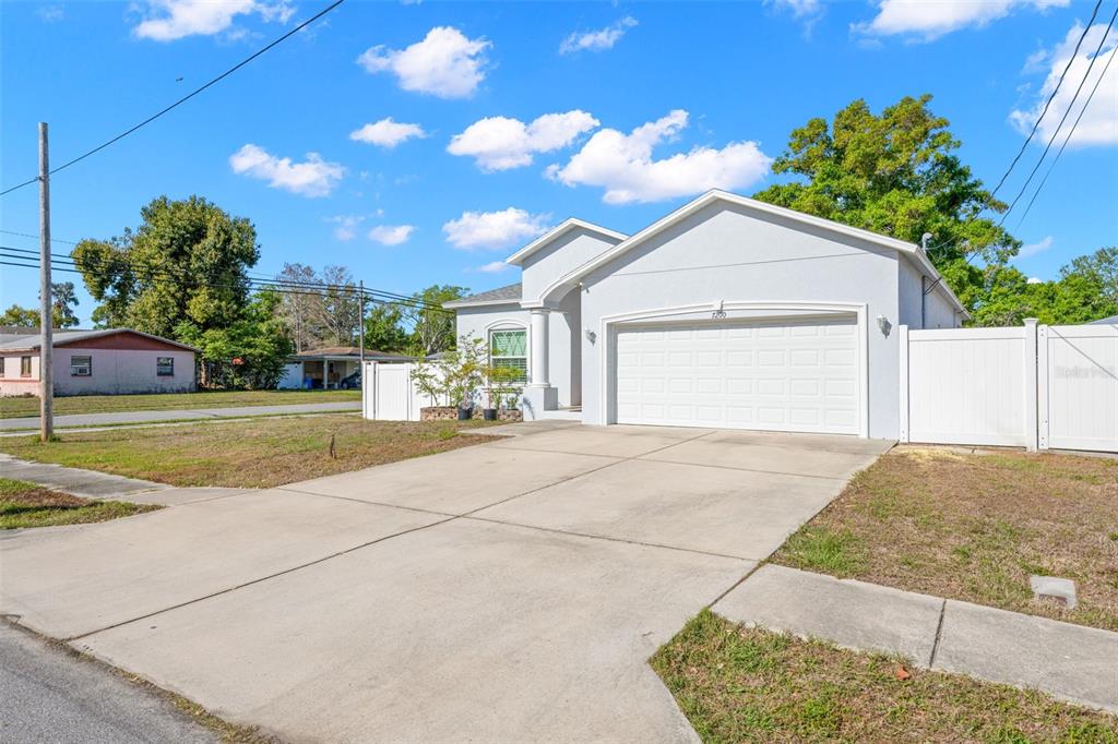 A light gray single-story house features a two-car garage and a concrete driveway — 7200 62ND WAY N, PINELLAS PARK, FL