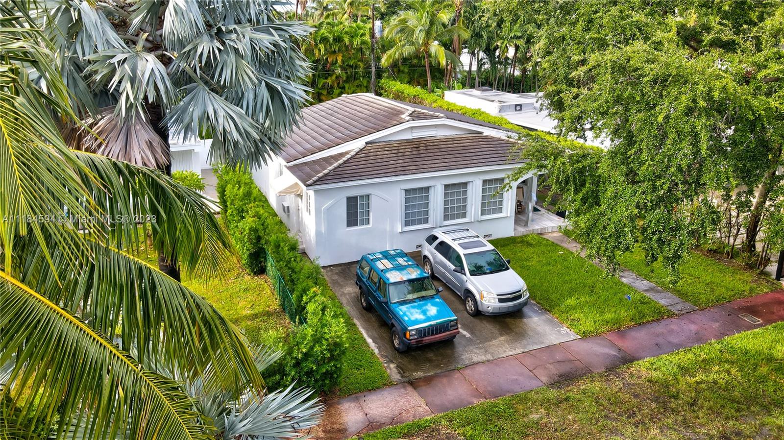 An aerial view shows a white single-story house with a driveway holding two parked cars — 535 W 51st St, Miami Beach FL 33140, MIAMI BEACH, FL