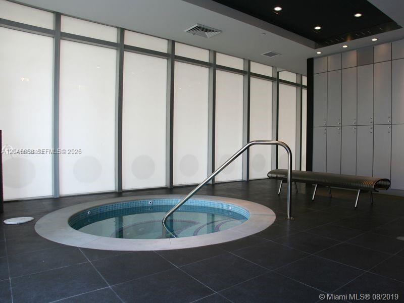 A circular hot tub with a metal handrail sits on a dark tiled floor — 500 Brickell Ave # 2006, Miami FL 33131, MIAMI, FL