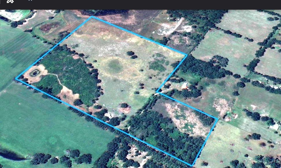 An aerial view shows a large, irregularly shaped plot of land outlined in blue — SE 51ST LANE, CENTER HILL, FL