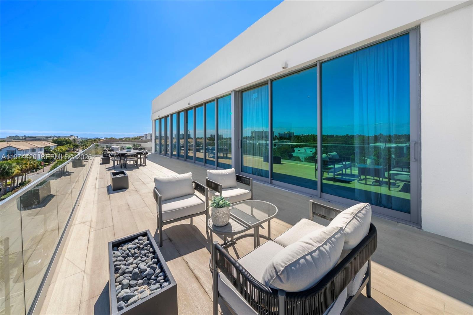 A spacious outdoor balcony features modern patio furniture, a fire pit, and floor-to-ceiling glass doors — 246 NE 6TH AVE PH, Delray Beach FL 33483, DELRAY BEACH, FL