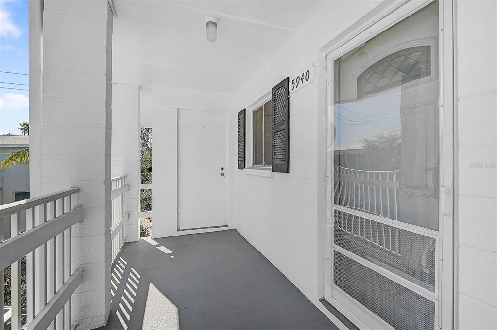 A covered exterior balcony features a gray floor, white walls, and a screen door — 5940 EASY STREET UNIT K31, BRADENTON, FL