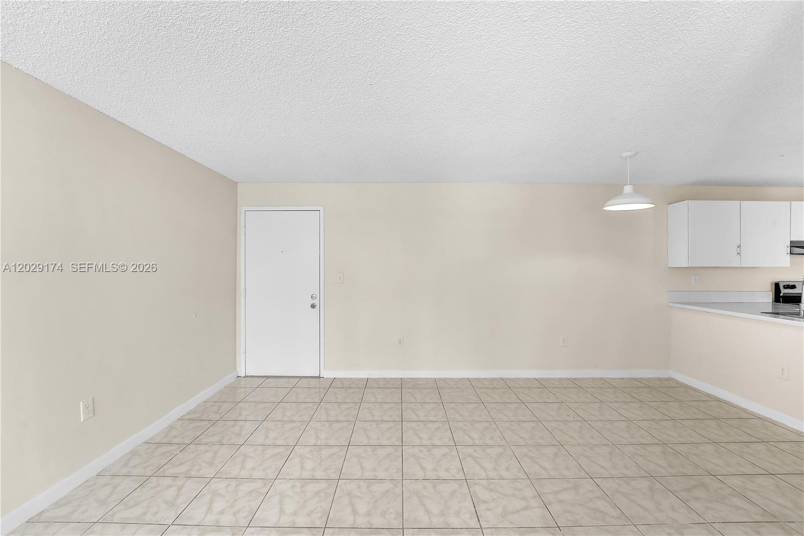 An empty room features beige walls, a white door, and light-colored tile flooring — 210 SW 11th St # 209, Miami FL 33130, MIAMI, FL