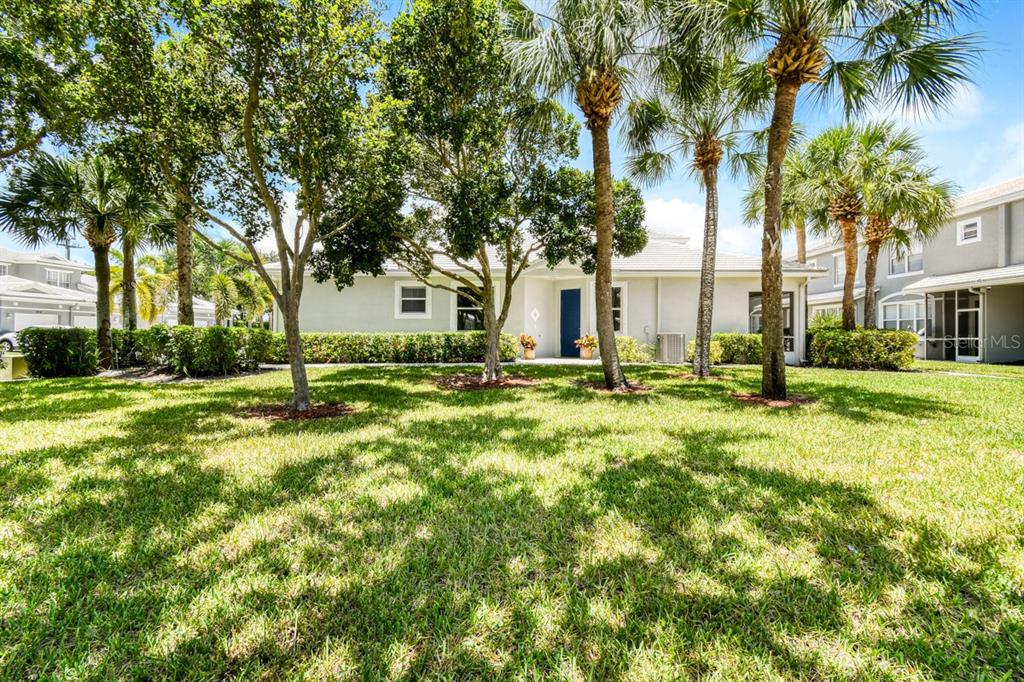 A single-story house with a blue front door is surrounded by trees and green lawn — 4952 SOUTHARD STREET, GREENACRES, FL