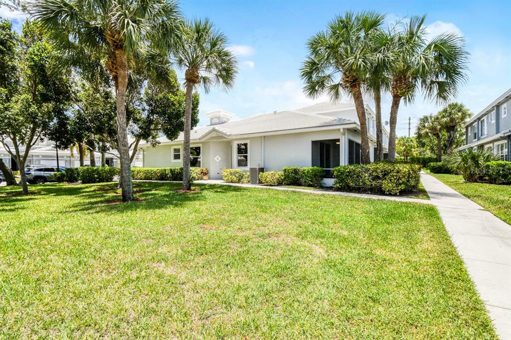 A light-colored single-story building with a screened patio and palm trees on a sunny day — 4952 SOUTHARD STREET, GREENACRES, FL