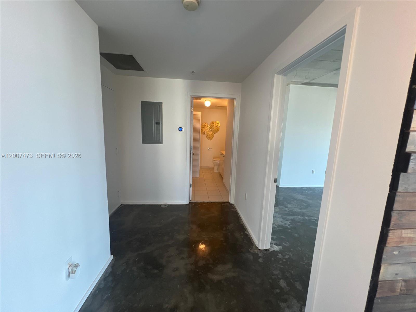 A hallway with concrete floors leads to a bathroom and an adjacent room — 3470 E Coast Ave # H0501, Miami FL 33137, MIAMI, FL