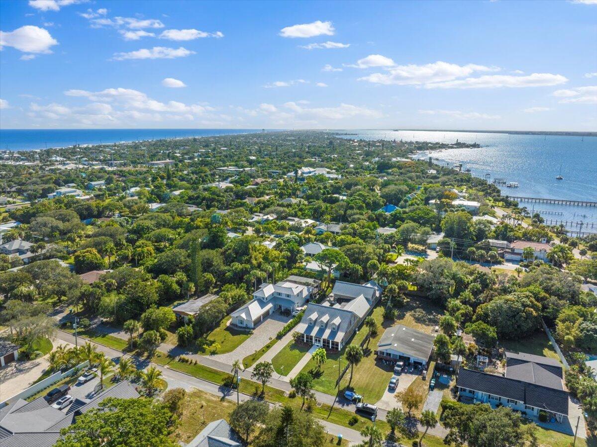 An aerial view of a coastal neighborhood featuring houses surrounded by dense trees and water — 531 Sunset Boulevard, Melbourne Beach FL 32951, MELBOURNE BEACH, FL