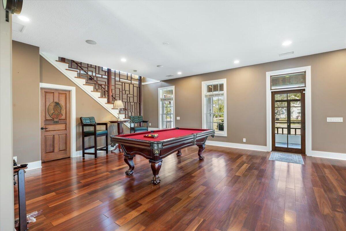 A game room features a pool table, hardwood floors, and a decorative wooden staircase — 531 Sunset Boulevard, Melbourne Beach FL 32951, MELBOURNE BEACH, FL