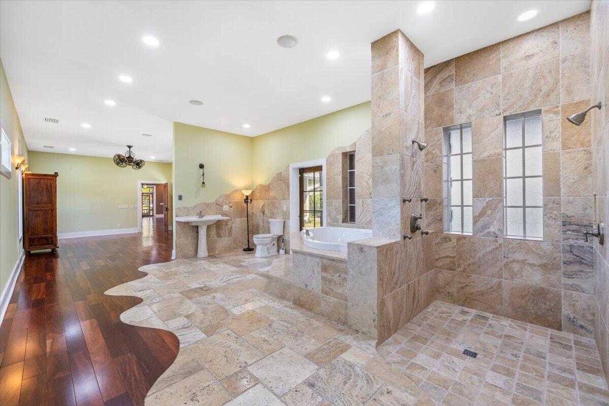 A spacious bathroom features a large walk-in tiled shower, a soaking tub, and hardwood flooring — 531 Sunset Boulevard, Melbourne Beach FL 32951, MELBOURNE BEACH, FL