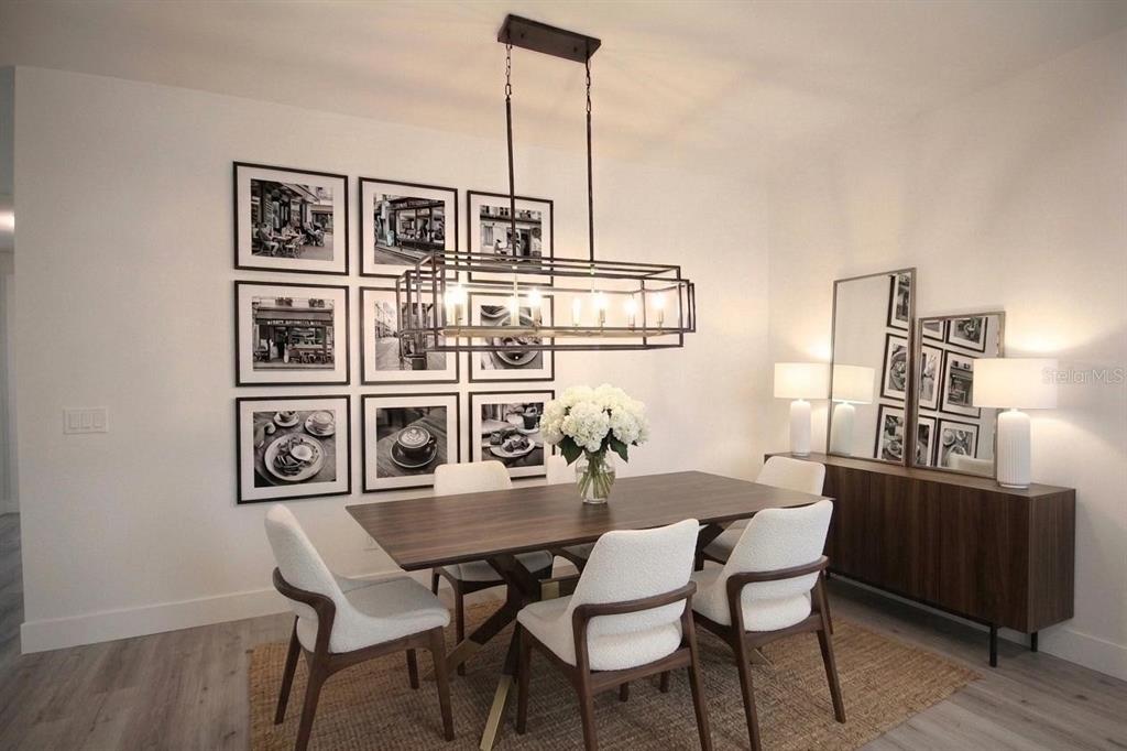 A dining room featuring a rectangular wood table, six chairs, and a linear metal chandelier — 4102 NW 26TH DRIVE, GAINESVILLE, FL