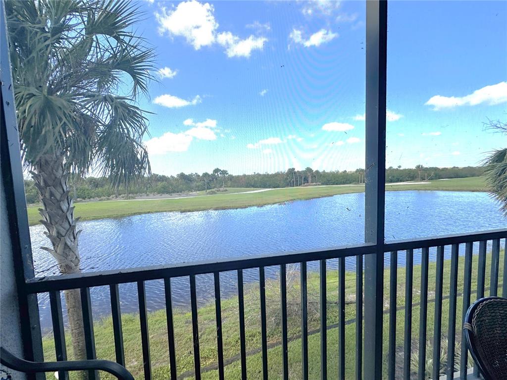 A screened-in porch overlooks a pond and a golf course under a blue sky — 14081 HERITAGE LANDING BOULEVARD UNIT 223, PUNTA GORDA, FL