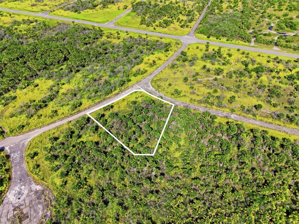 An aerial view shows a vacant, wooded lot outlined in white near paved roads — NO ADDRESS, PALM BAY, FL