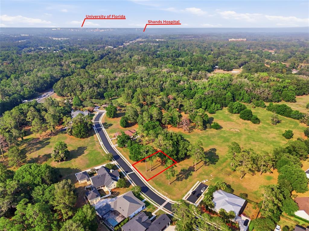 An aerial view shows a vacant residential lot outlined in red within a wooded neighborhood — 6713 SW 40TH TERRACE, GAINESVILLE, FL